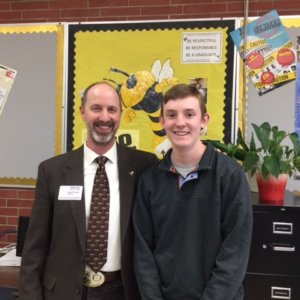 Ravalli County Commissioner Greg Chilcott with a student posing for a picture at the front of the classroom