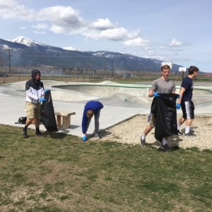 Five students pick up trash around the skate park