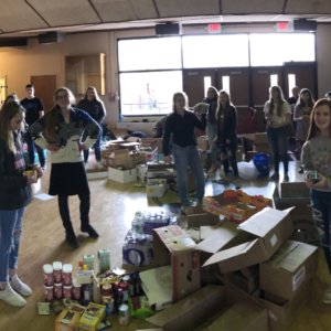19 Students load food into boxes in the lobby of the High School gymnasium