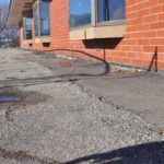 Photo of Elementary School showing the slope which leads water to drain under the building rather than away.