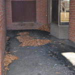 Photo of area outside Elementary School Drainage with drainage that leads under the building