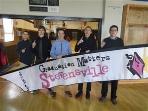 Five Stevensville High School Students hold a Graduation Matters Stevensville banner
