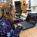 A primary student girl uses her new chromebook